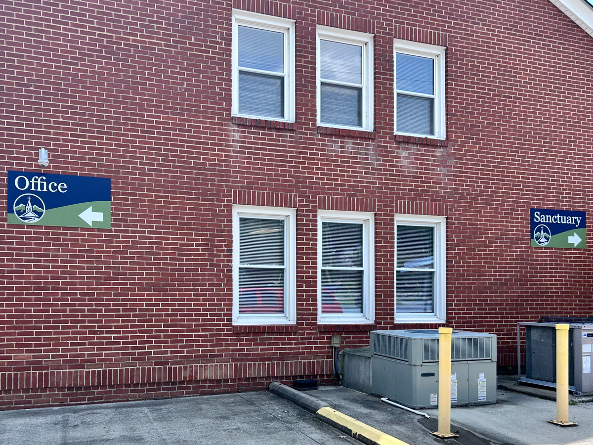 Office and Sanctuary directional church signs installed on brick exterior walls at First Baptist Church of Black Mountain