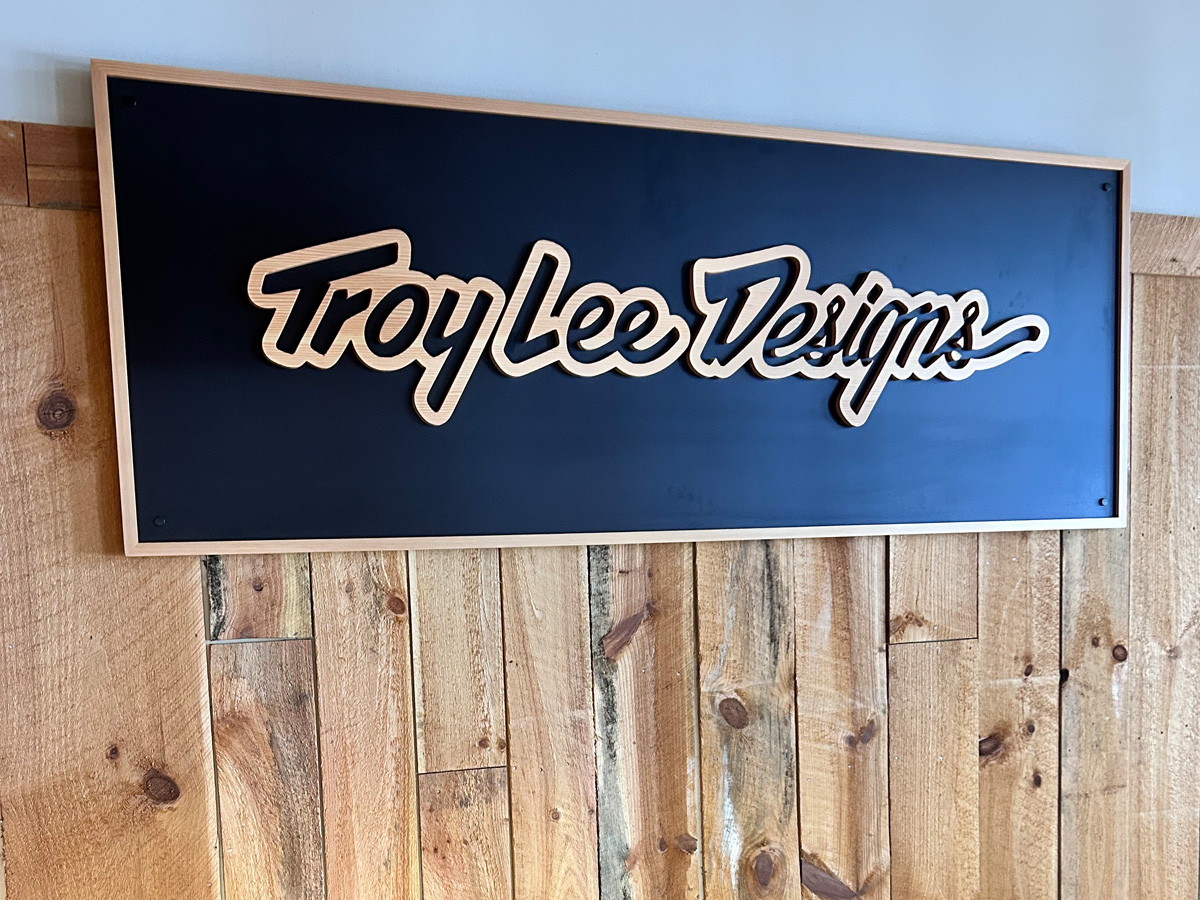 Troy Lee Designs dimensional interior sign with CNC carved raised wood lettering installed in Pisgah Forest North Carolina