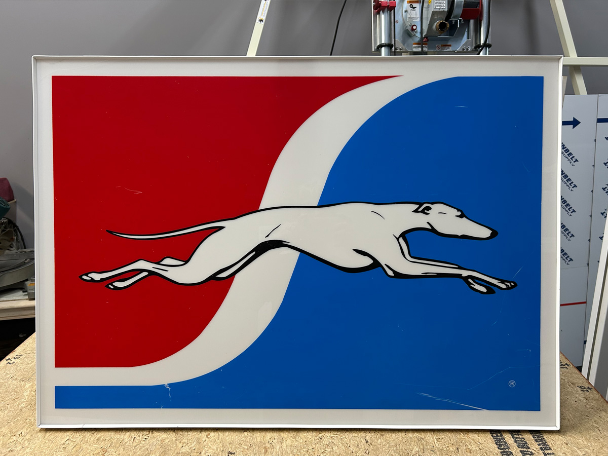 Restored original Greyhound cabinet sign face with new trim cap