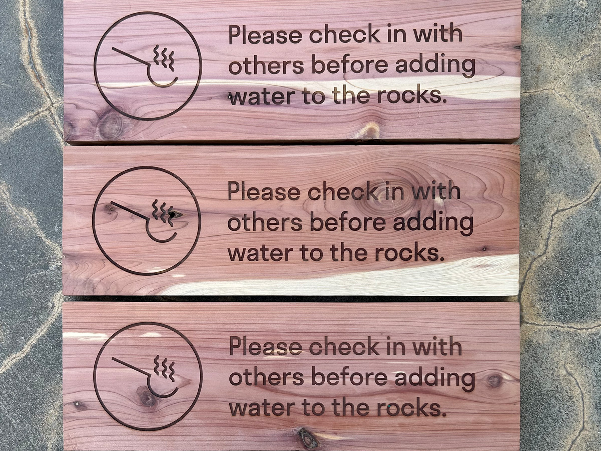 Laser-engraved locally sourced Eastern red cedar sauna signs with natural pink wood color